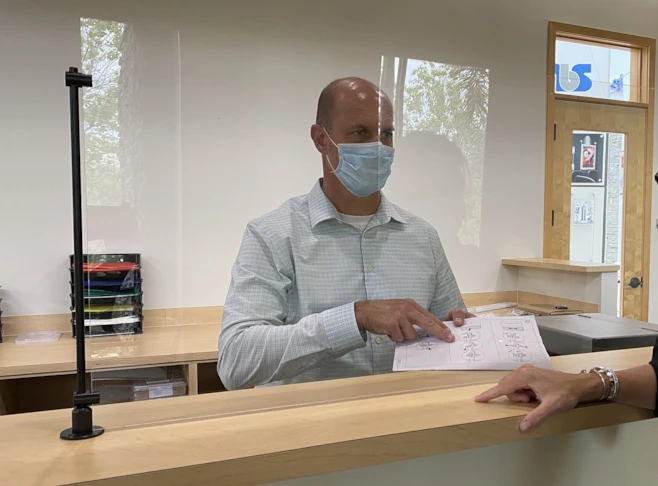 Man in Face Mask Using Social Distancing Counter Safety Screen