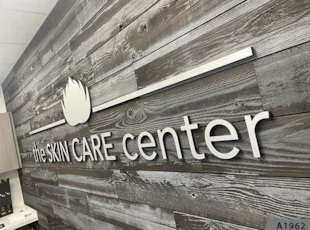 3D Letters and 3D Logo with Brushed Aluminum Metal Faces and black Returns stud-mounted to textured Lobby Wall  | Healthcare | Lake Forest, IL | Metal